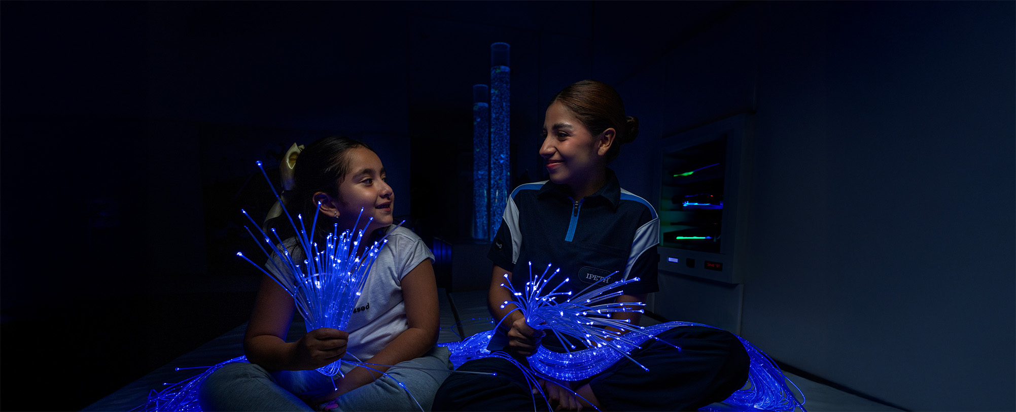 chica fisioterapeuta y niña en cuarto multosensorial