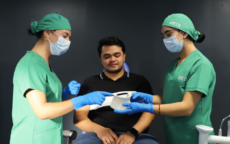alumnas practicando con paciente real en ipeth universidad para odontologia